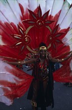 ENGLAND, London, Notting Hill carnival woman in extravagant red costume.