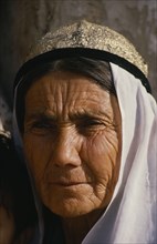 CHINA, Xinjiang, Kashgar, Portrait of an old woman at the Sunday market. Wearing a white head scarf