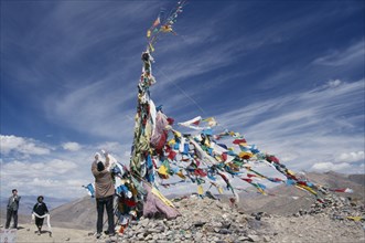CHINA, Tibet, Tscho La, "Tibetans adding katas, Buddhist ceremonial scarves, to the prayer flags at