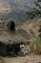 COLOMBIA, Sierra Nevada de Santa Marta, Kogi Tribe, "Young man stands outside the family home above