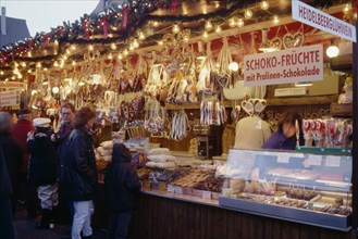 GERMANY, Bayern, Bamberg, "Customers at decorated stall in Christmas market selling iced biscuits,
