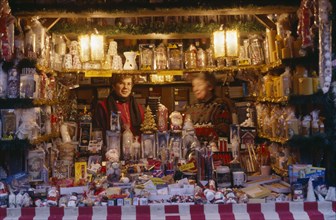 GERMANY, Bayern, Nuremberg, "Women vendors in decorated stall in Christmas market selling