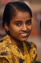 INDIA, Uttar Pradesh, Varanasi, Head and shoulders portrait of young girl on the ghats wearing a