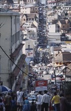 MADAGASCAR, Antananarivo, Downtown area. People walking down towards a busy road running between