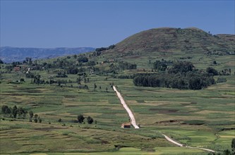 MADAGASCAR, Landscape, Near Antsirabe. Elevated view over patchwork fields with a dirt road running