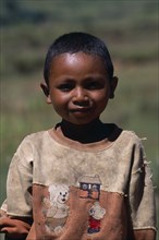 MADAGASCAR, People, Children, Portrait of a young boy wearing a dirty shirt printed with teddy