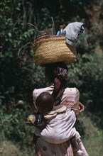 MADAGASCAR, People, Women, Near Ambositra. Portrait of a woman carrying a baby in a sling on her