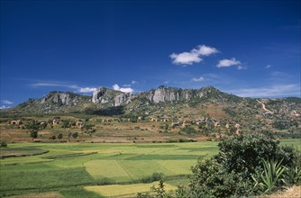 MADAGASCAR, Landscape, Road to Ambalavao.  View across green paddy fields towards a village of