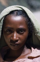 MADAGASCAR, People, Children, Road to Ranomanfana. Head and shoulders portrait of a girl wearing a
