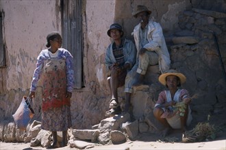 MADAGASCAR, People, Road to Ranomanfana. Two men sitting on steps at side of building next to two