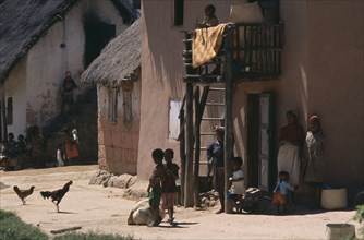 MADAGASCAR, People, Road to Ranomanfana. Women and children in village with thatched huts and
