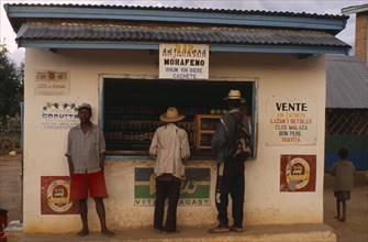 MADAGASCAR, Ihosy, Men standing at a kiosk which sells rum and beer