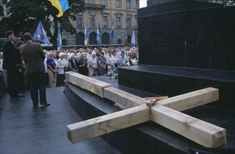 UKRAINE, Lvov, "A large wooden cross lays flat in front of a crowd, dedicated to the Gulag victims"