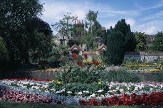 ENGLAND, East Sussex, Lewes, Southover Grange Gardens. View across flower beds towards Elizabethan
