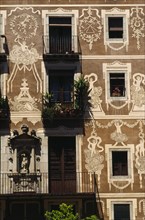 SPAIN, Catalonia, Barcelona, Decorated exterior of flats on the Plaza Delfi with potted plants and