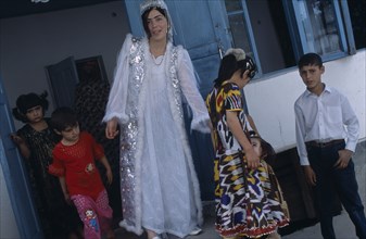 TAJIKISTAN, Wedding, "The bride wearing a white dress and silver jacket, with children around her