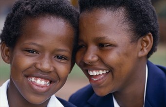 SOUTH AFRICA, Gauteng, Johannesburg, Portrait of two laughing schoolgirls.