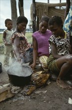 CONGO, Food, Women cooking cassava over wood burning fire.