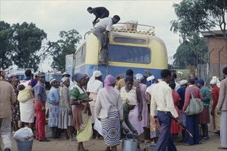 ZIMBABWE, Harare, Crowds around unloading bus.