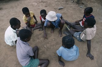 ZIMBABWE, People, Children playing mancala game of bao using stones and depressions in ground