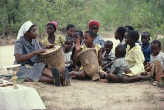 ZIMBABWE, Victoria District, Bondolfi Mission, Nun teaching children to play drums in mission