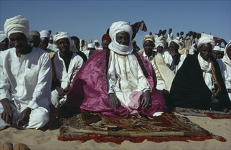 CHAD, Prayer, Muslim chief at prayer during festival surrounded by crowd.