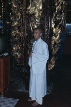VIETNAM, Mekong Delta, My Tho, Monk wearing white robes in Vinh Trang Pagoda