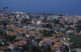 PORTUGAL, Madeira, Funchal, Elevated view over roof tops with the Motorway flyover leading to the