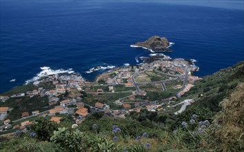 PORTUGAL, Madeira, Elevated view from the north coastal road over Porto do Moniz rooftops and
