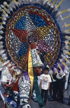 MEXICO, Mexico City, Our Lady of Guadaloupe Festival. Indian male dancer with large colorful