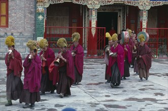 CHINA, Qinghai Province, Quezhang Lamasery, "Tibetan Yellow Hat Buddhists playing horns, drums and