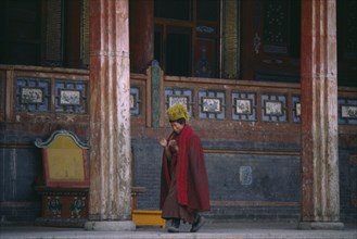 CHINA, Qinghai Province, Taer Lamasery, Tibetan Yellow Hat Buddhist monk calling other monks to