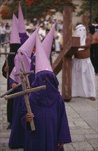 MEXICO, Oaxaca, "Young, masked penitents carrying wooden crosses during Easter parade. "