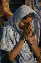 INDIA, Uttar Pradesh, Varanasi, Young woman praying.