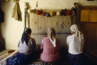 TURKEY, General, Women near Konya weaving carpets in traditional way using hand loom.