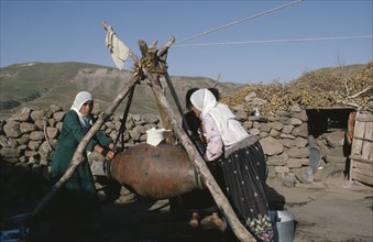 TURKEY, East, Women churning milk in rural area.