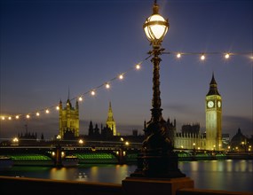 ENGLAND, London, Westminster. Houses of Parliament and Westminster Bridge illuminated at night seen