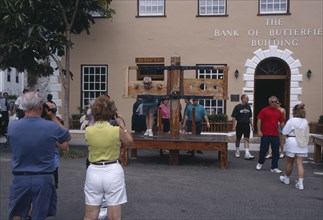 BERMUDA, St George, Tourists in kings Square with people in the foreground taking pictures of a man