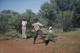 AUSTRALIA, Northern Territory, Alice Springs, Aborigine man throwing a Boomerang with a man and
