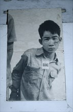 CAMBODIA, Phnom Penh, Tuol Sleng Museum. Photograph of a young male prisoner in a Khmer Rouge
