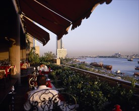 UAE, Dubai, View from restaurant balcony over the Dubai Creek with tall building in the distance.