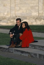 ITALY, Tuscany, Pisa, Young stylish couple sat on steps of the Cathedral in the Piazza del Duomo