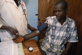 GUINEA, Kissidougou Camp, Man in refugee camp for Sierra Leonean  refugees having his blood