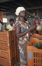 IVORY COAST, Farming, Fruit, Women trimming and packing pineapples.