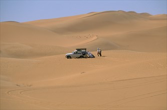 LIBYA, Sahara Desert, Tourists four by four vehicle stuck in Saharan sand.