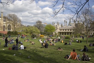 ENGLAND, East Sussex, Brighton, The Royal Pavilion gardens with people relaxing in the spring
