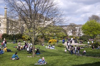 ENGLAND, East Sussex, Brighton, The Royal Pavilion gardens with people relaxing in the spring