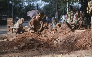 BANGLADESH, Dhaka, Men and women stone breaking with bricks and hammers