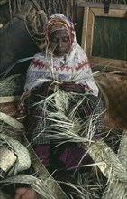 KENYA, Arts, Basket Making, Somali woman making basket from woven fibres in Dadaab refugee camp.