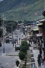 BHUTAN, Thimpu, "Street scene with people, traffic and roadside buildings."